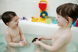 Двое детей купается в ванне